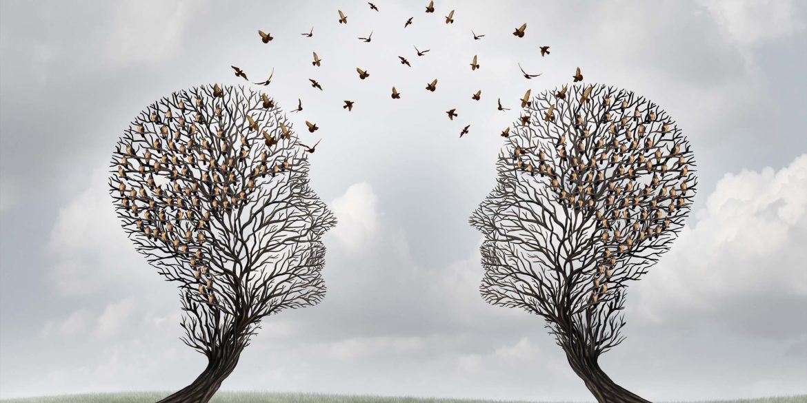 Two barren trees shaped like human heads surrounded by birds