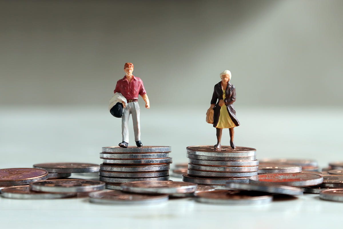 Toy figurines of man and women on equal stacks of coins