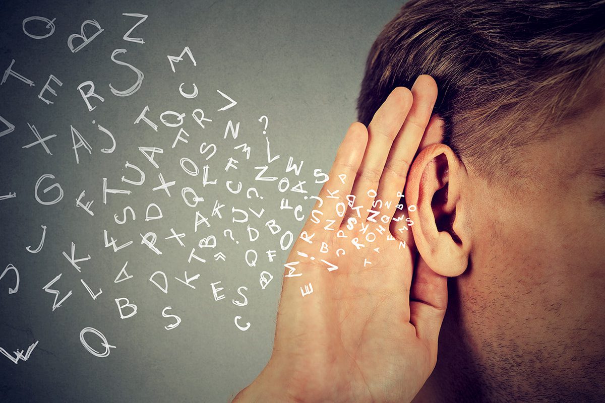 A person cups a hand behind their ear as illustrated letters spread across a gray background.
