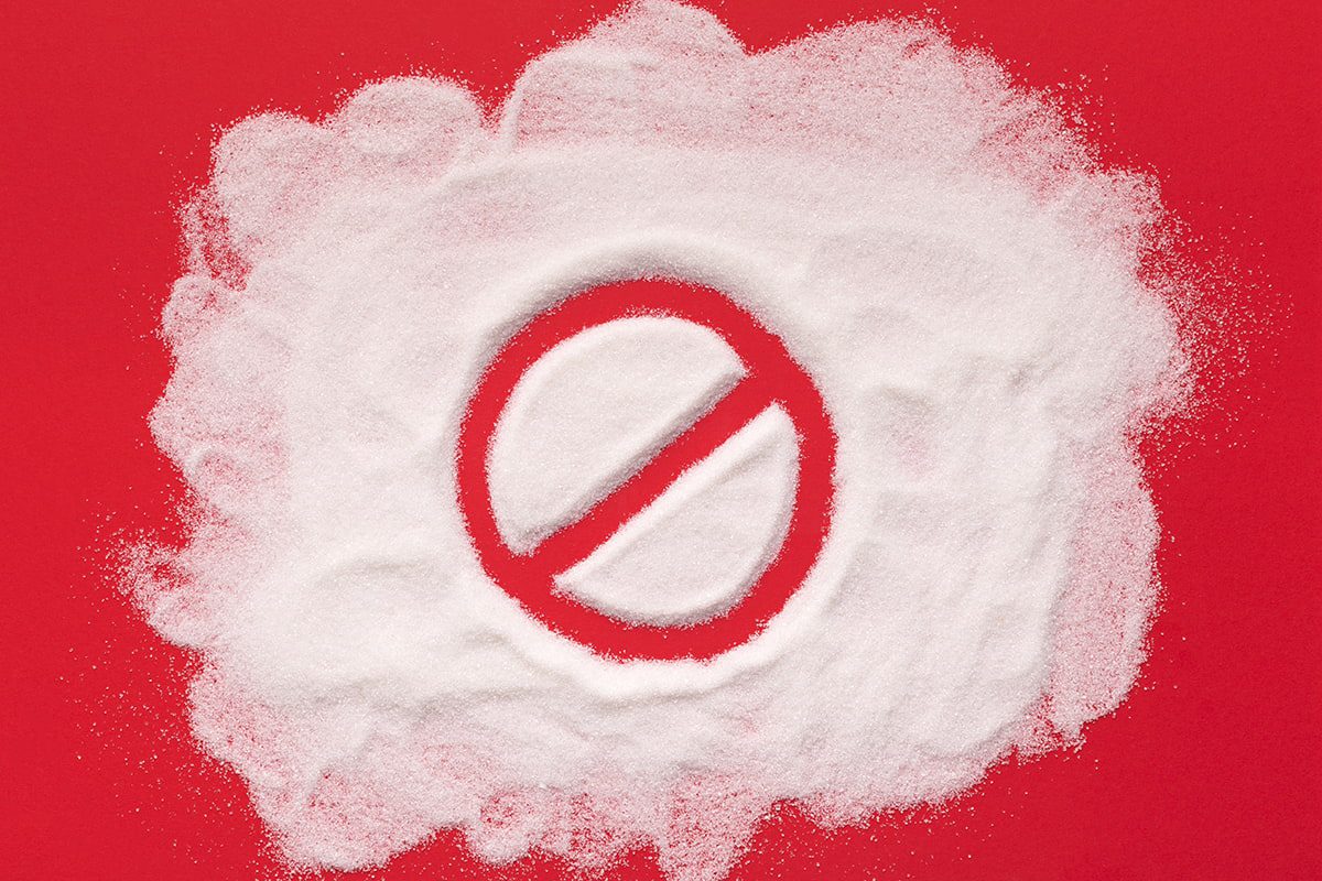 A prohibition symbol is traced in white granules on a red background.