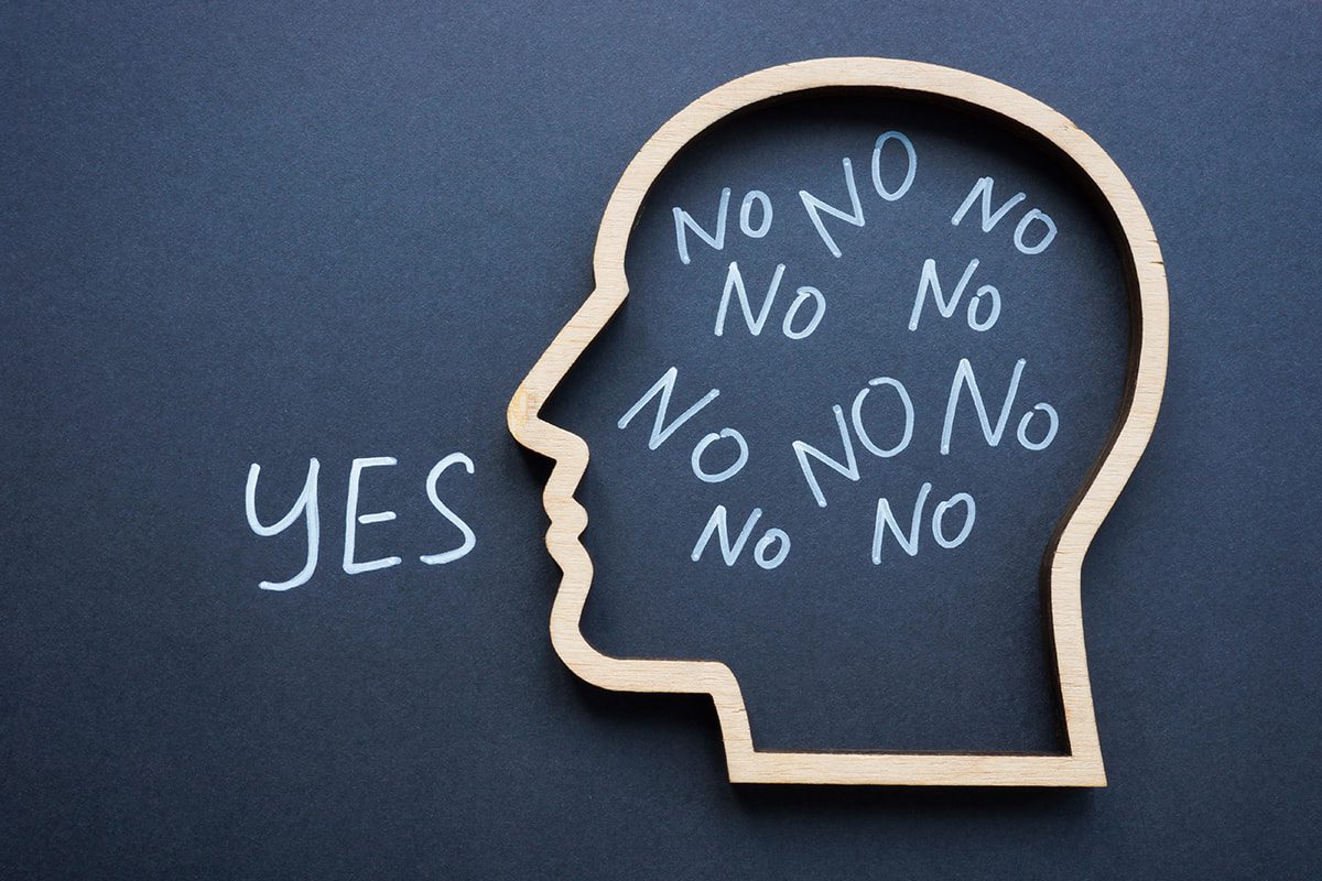 A wooden head outline contains repeated "No" words, with "YES" written outside it on a dark background.
